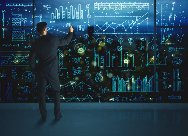 Businessman drawing business statistics on glass wall